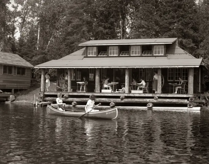 1950S Two Women Paddling In Canoe By Cabin In Lake Algonquin Park Canada Summer Camp Rustic Log Cabin