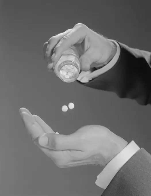 1960S Male Hands Shaking Two Aspirins Pills From Bottle