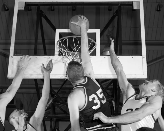 1960S Basketball Player Going Up For Shot With 2 Opposing Players Trying To Block