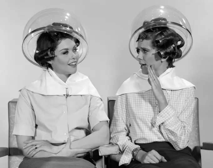 1960S Two Women Sitting Together Gossiping Under Hairdresser Hair Dryer