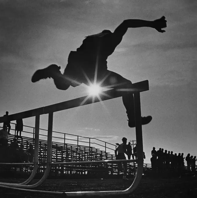 1970S Sun Rays Through Silhouette Of Man Jumping Track Field Hurdle