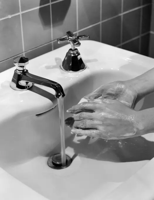 1950S Woman'S Hands Lathering Up With Bar Of Soap Under Bathroom Faucet