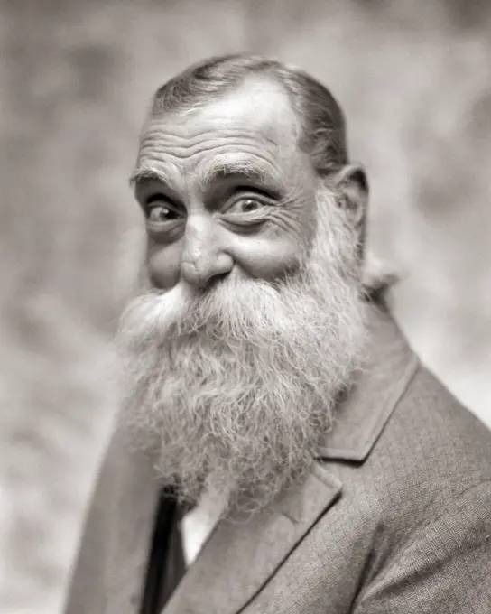 1920s 1930s MAN IN CIVILIAN ATTIRE LARGE WHITE BEARD MUSTACHE AND SMILING EYES LOOKING AT CAMERA MIGHT BE SANTA CLAUS IN MUFTI