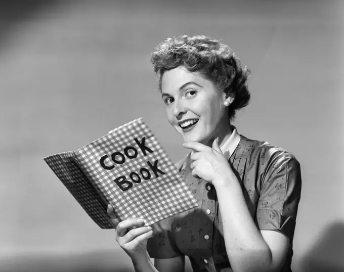 1950S Woman Holding Cookbook Smiling