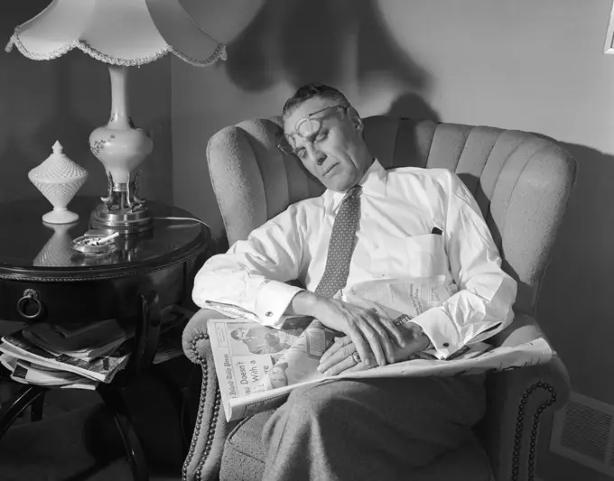 1950S Middle Aged Man Asleep Sleeping In Chair Reading Newspaper Eye Glasses Pushed Up On Forehead