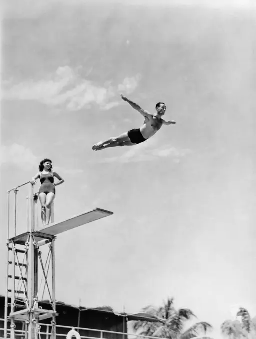 1940S Man Swan Diving Off High Diving Board Woman Watching