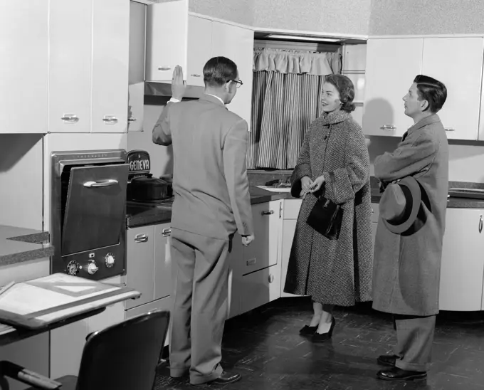 1950S Salesman In Model Kitchen With Couple