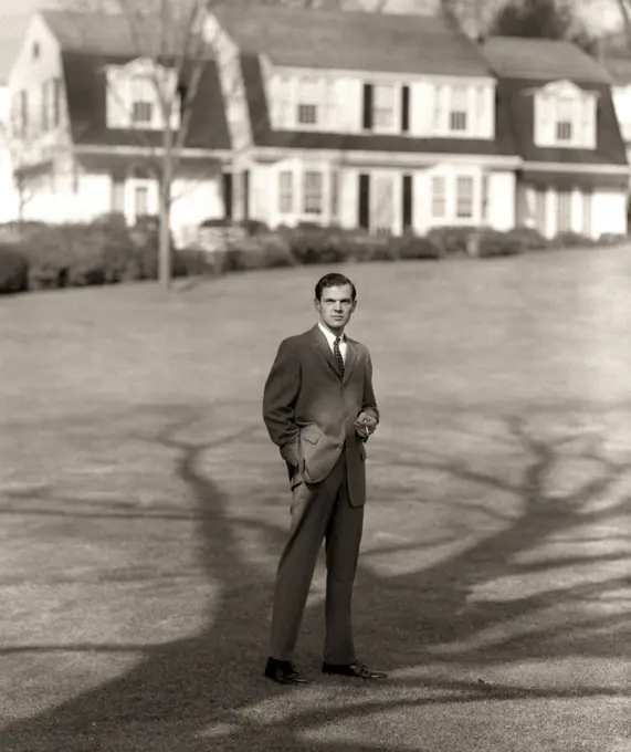 1950S Man Upscale Businessman Executive In Gray Flannel Suit And Tie Standing On Suburban Home Lawn