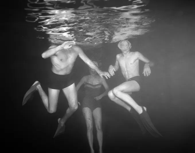 1950S View Of Three Swimmers Under Water