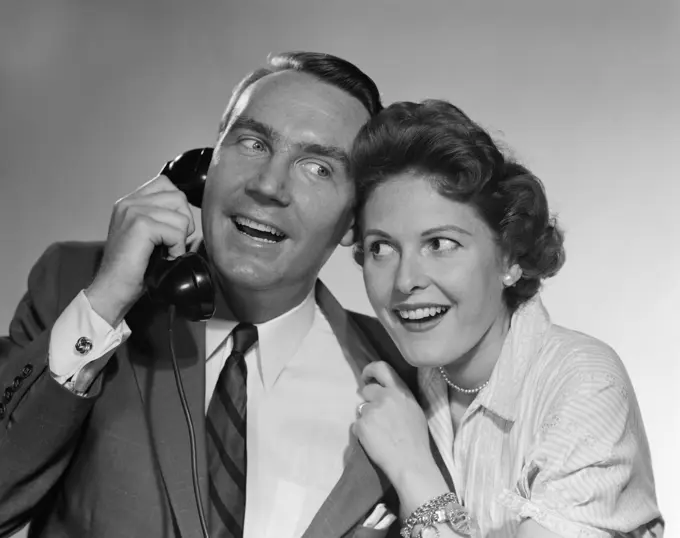 1950S Man On Telephone Woman Leaning In Listening Both Smiling