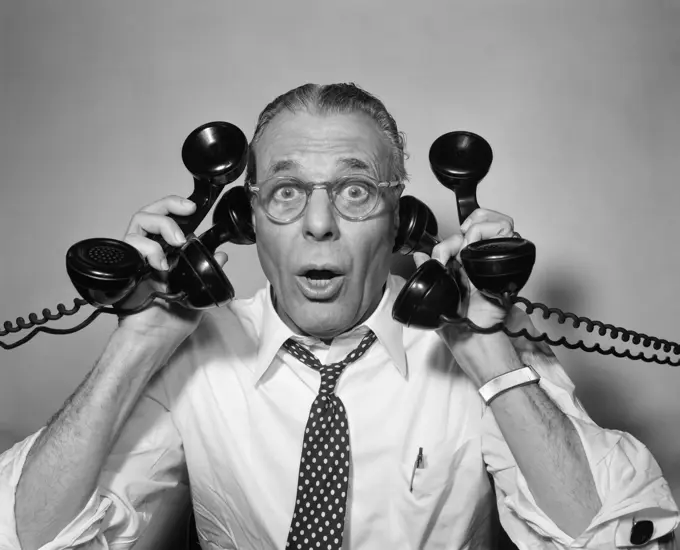 1950S Man With Glasses Holding Four Black Telephones