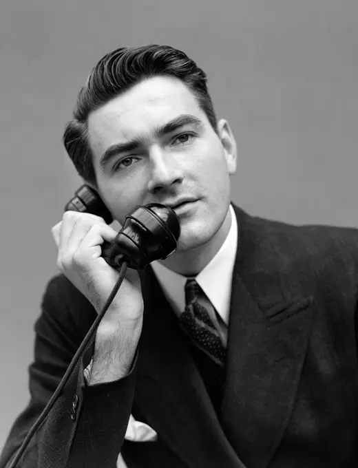 1930S Portrait Serious Man In Dark Suit Talking On Telephone