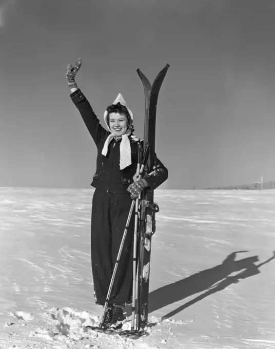 1930S Smiling Woman Holding Skis In Snow Waving