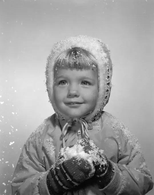 1950S Little Girl Posing In Winter Jacket Mittens And Holding Snow