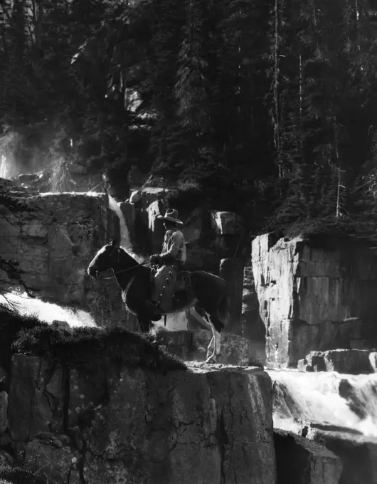 1920S 1930S Cowboy On Horse By Waterfall In Pine Forest Giants Steps Paradise Valley Canada Western Frontier