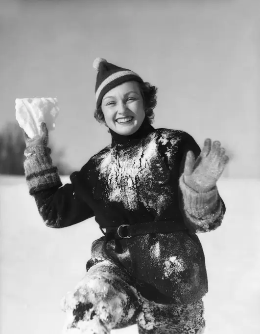 1930S Smiling Young Woman Covered In Snow Throwing Piece Of Snow