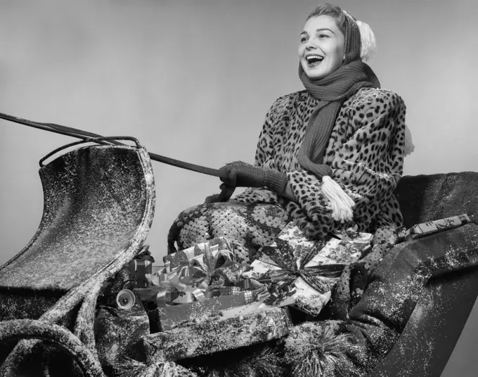 1950S Laughing Woman In Leopard Skin Fur Coat Driving Christmas Sleigh Loaded With Presents