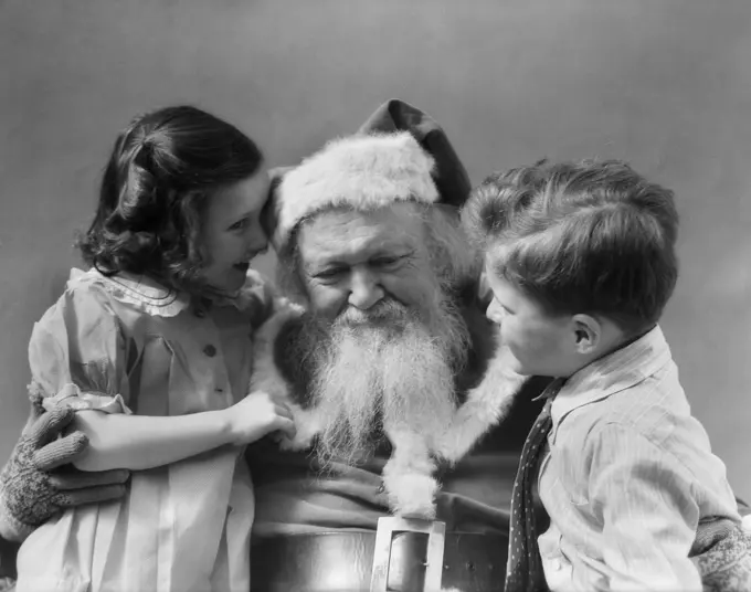 1930S Little Boy With Girl Whispering Telling Santa Claus What She Wants For Christmas