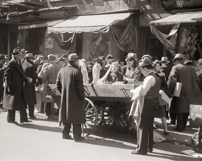 1940s 1950s CROWD OF SHOPPERS MEN WOMEN LOOKING FOR A DEAL AT PUSHCART MARKET ON LOWER EAST SIDE OF MANHATTAN NEW YORK CITY USA