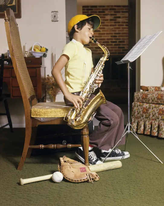 1960s 1970s BOY PRACTICING PLAYING SAX SAXOPHONE BASEBALL CAP BAT BALL GLOVE AT FEET