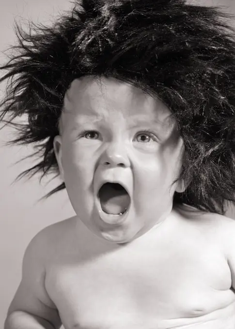 1960s BABY BOY ANGRY SCREAMING WEARING WILD BLACK WIG OR HAT LOOKING AT CAMERA