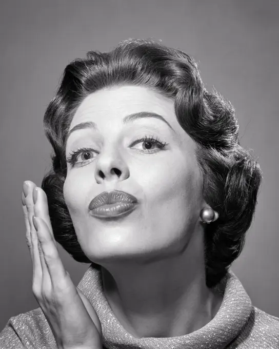 1950s 1960s BRUNETTE WOMAN LOOKING AT CAMERA PUCKERING HER LIPS AS IF TO KISS