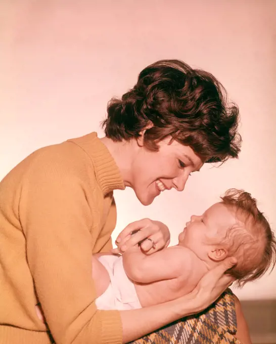1960s SMILING HAPPY MOTHER HOLDING BABY LAP MOTHERS BABIES PARENT PARENTING FAMILY FAMILIES MOTHERHOOD