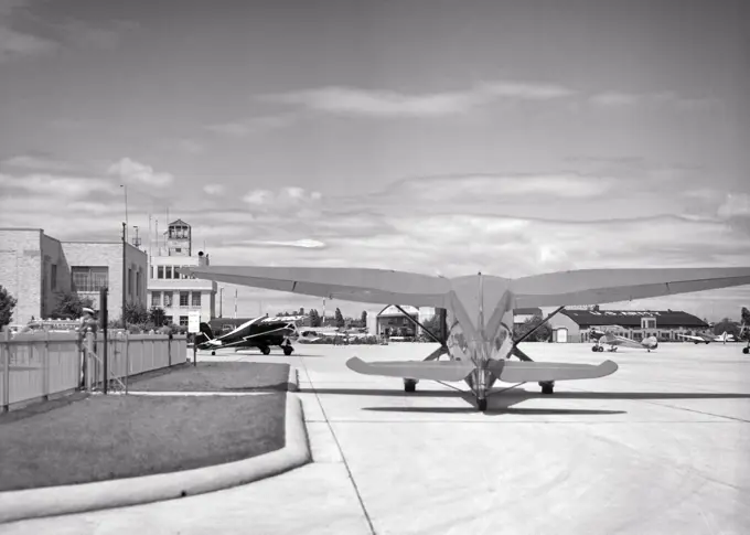 1930s REAR VIEW OF STINSON GULLWING AIRPLANE SITTING ON TARMAC BOSTON AIRPORT NOW LOGAN AIRPORT IN EAST BOSTON MA USA