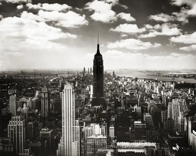 1950s EMPIRE STATE BUILDING SILHOUETTED LOOKING SOUTH FROM THE RCA BUILDING AT ROCKEFELLER CENTER MIDTOWN MANHATTAN NYC USA