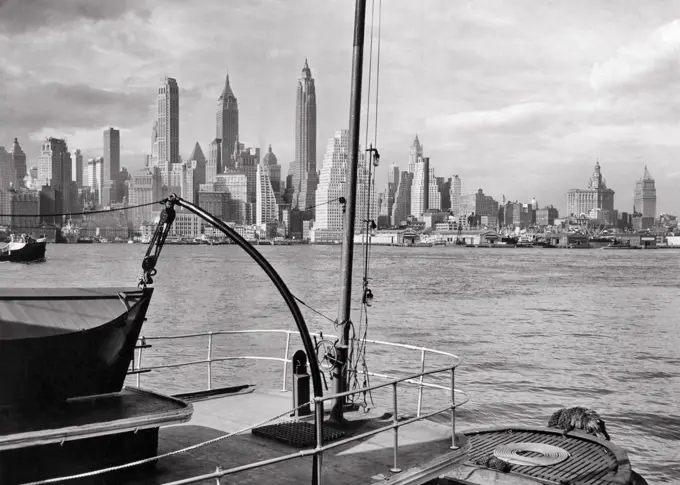 1940s VIEW OF LOWER MANHATTAN ISLAND SKYLINE OF SKYSCRAPER BUILDINGS FROM DECK OF SHIP DOCKED IN BROOKLYN NEW YORK CITY NY USA