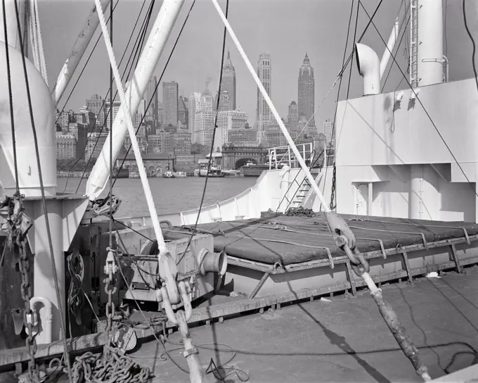 1940s DOWNTOWN SKYSCRAPER BUILDING SKYLINE FROM DECK OF FREIGHTER NAVIGATING HUDSON RIVER NEW YORK CITY NEW YORK USA