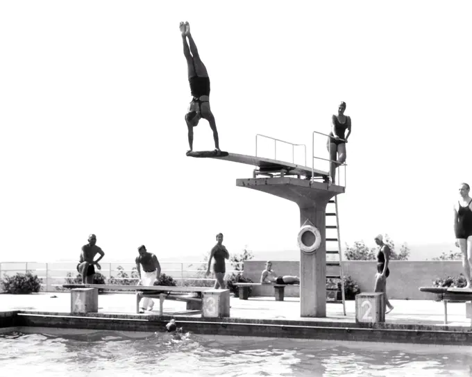 1930s 1935 MAN DOING HANDSTAND ON DIVING BOARD SWIMMING POOL THE OPELBAD IN NEROBERG HILL OVERLOOKING WIESBADEN GERMANY