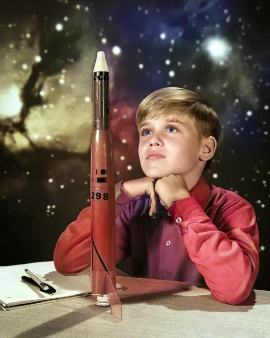 1960s DAY DREAMING BOY WITH MODEL ROCKET AND OUTER SPACE BACKGROUND