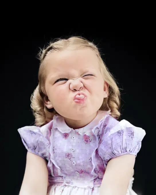 1940s PORTRAIT OF GIRL STICKING OUT TONGUE WRINKLED UP NOSE