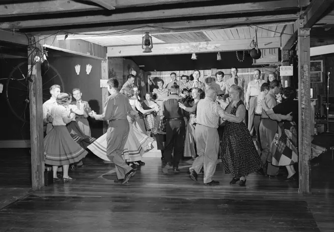 1950S Square Dancers In Country Western Outfits Dancing To Music Of A Small Band In A Barn