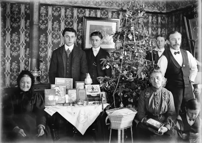 1890 1890s TURN OF CENTURY GROUP PORTRAIT FAMILY THREE GENERATIONS POSING BY CHRISTMAS TREE GIFTS ON TABLE