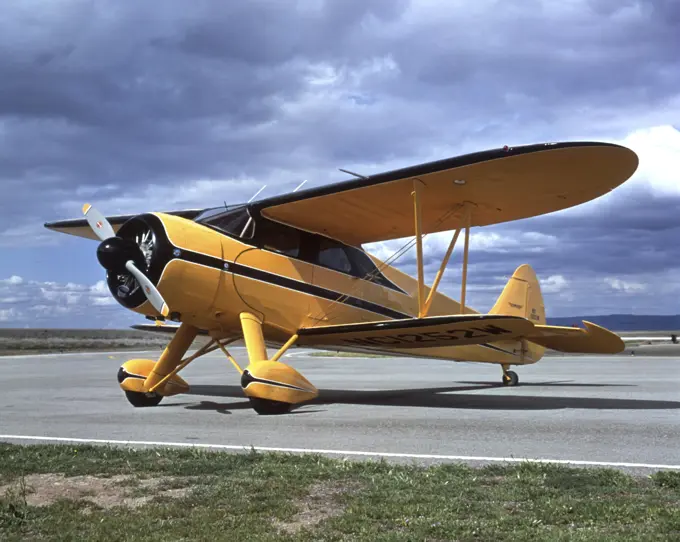 AIRPLANE YELLOW AND BLACK BI-PLANE  ON AIRPORT TARMAC