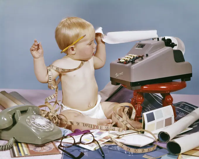 1960s DESIGNER BABY SITTING TANGLED IN MEASURING TAPE WITH ADDING MACHINE BLUE PRINTS TELEPHONE PAINT SAMPLES