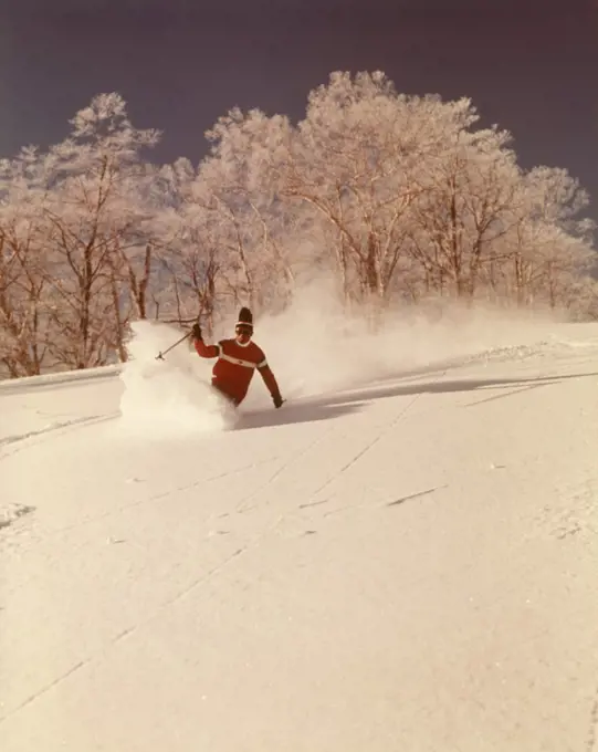 1960s 1970s MAN SKIER SHUSHING DOWN SLOPE KICKING UP SPRAY OF POWDER SNOW WEARING RED SWEATER