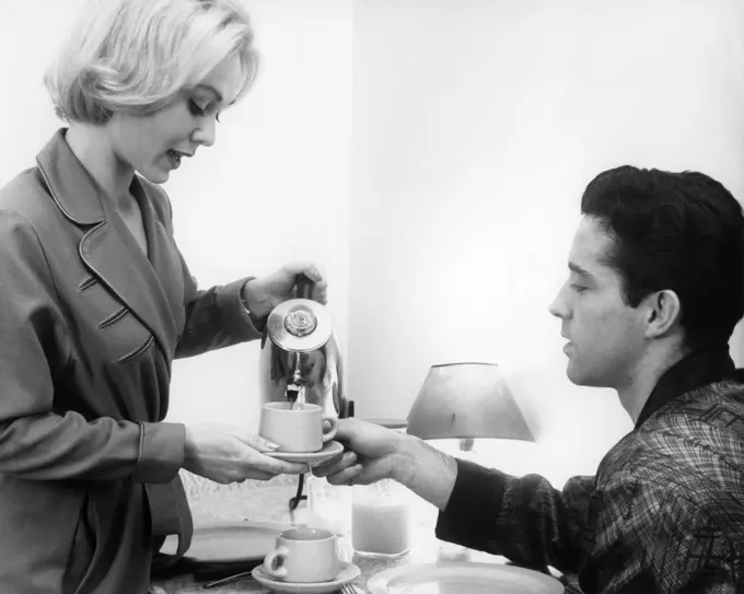 1960s YOUNG COUPLE WEARING ROBES  HAVING MORNING COFFEE FROM ELECTRIC PERCOLATOR COFFEE POT