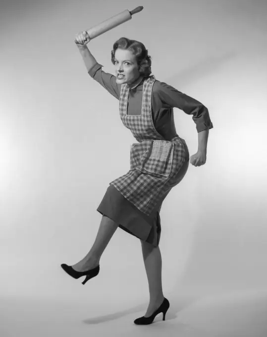 1950S Angry Housewife In Apron Wielding Rolling Pin Over Her Head