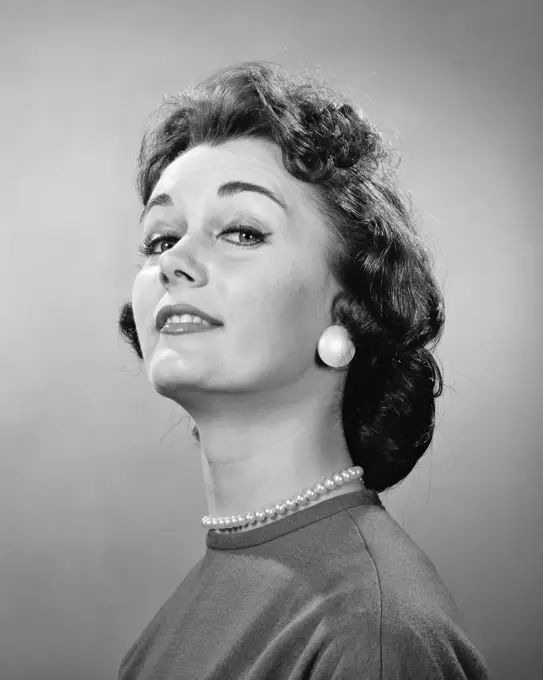 1950s 1960s BRUNETTE WOMAN CHIN UP SUPERIOR THOUGHTFUL FACIAL EXPRESSION LOOKING AT CAMERA