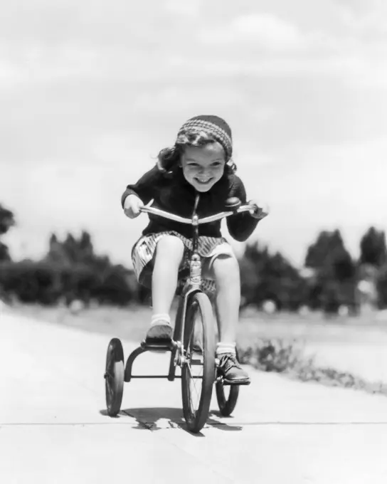 1930s 1940s GIRL RIDING TRICYCLE ON SIDEWALK