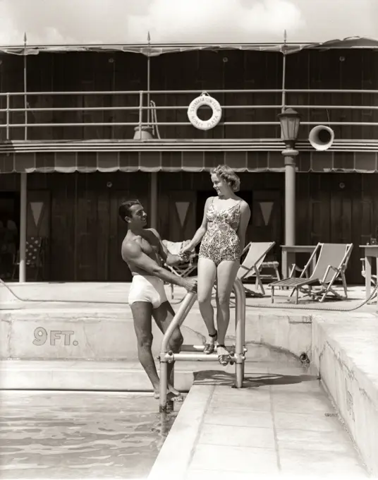 1930s MAN WOMAN COUPLE IN BATHING SUITS POOL SIDE VACATION HOTEL MIAMI BEACH FLORIDA USA