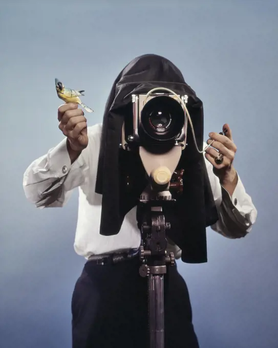 1960s PHOTOGRAPHER BEHIND VIEW CAMERA HOLDING UP BIRDIE READY TO SNAP PHOTO 