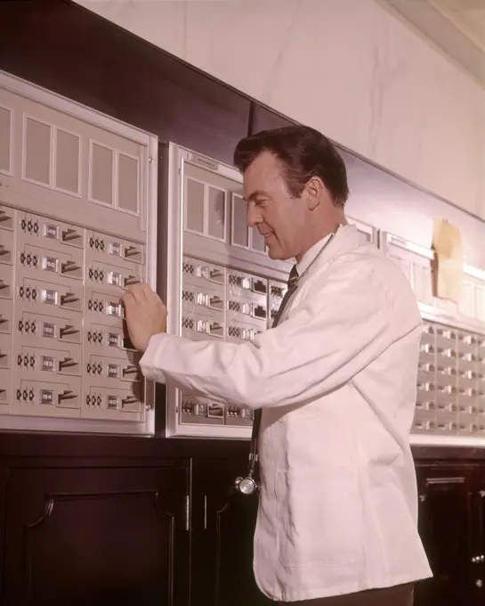 1960s MEDICAL DOCTOR RETRIEVING SUPPLIES FROM SECURE STORAGE