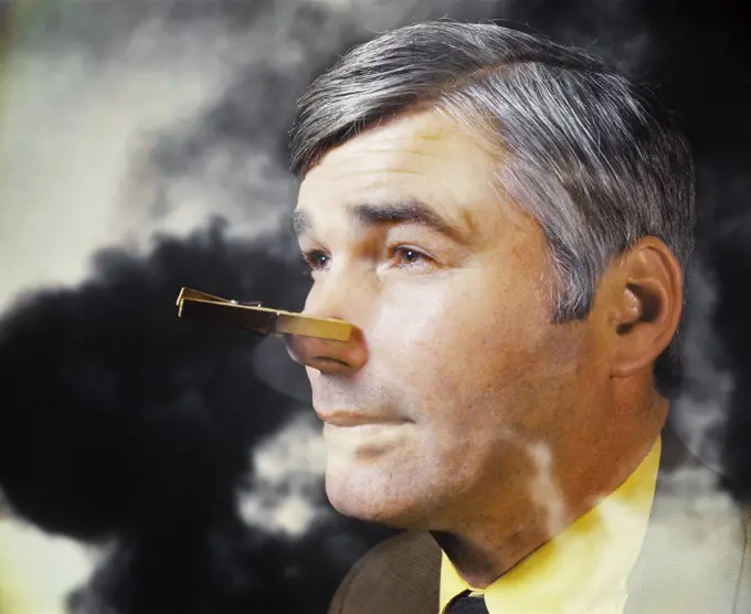 1970s MAN IN SMOKE BAD ATMOSPHERE WITH CLOTHESPIN ON HIS NOSE BECAUSE OF SMELL ODOR POLLUTION 
