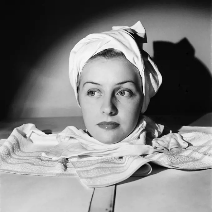 1950s PORTRAIT HEAD SHOT OF WOMAN RELAXING IN SPA SAUNA STEAM CABINET TOWEL WRAPPED AROUND HEAD