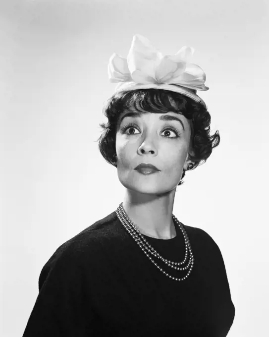 1960s BRUNETTE WOMAN WITH WIDE EYED EXPRESSION WEARING SILLY HAT hous