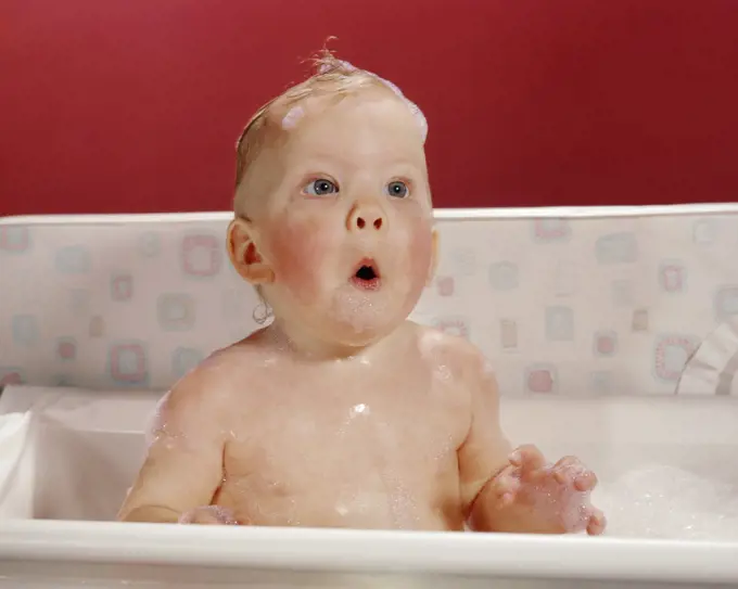 1960s EXCITED SURPRISED BABY IN BATHTUB SUDS ON HEAD AND FUNNY FACIAL EXPRESSION